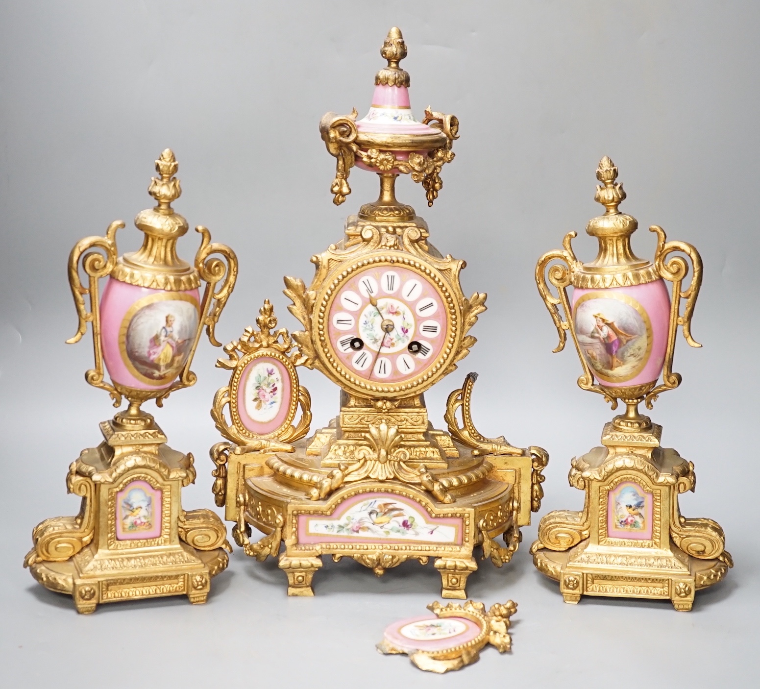 A French gilt metal and porcelain clock garniture. 36.5cm